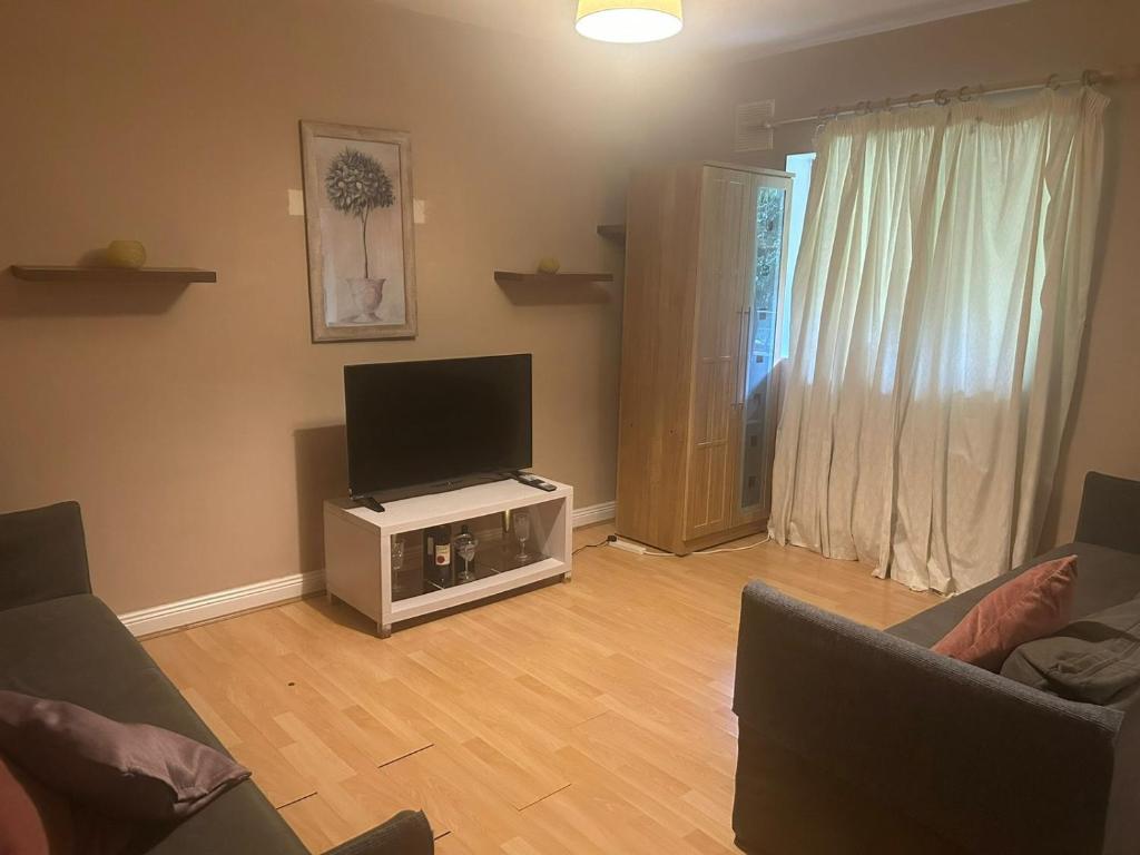 a living room with two couches and a flat screen tv at Kildare cozy home in Kildare