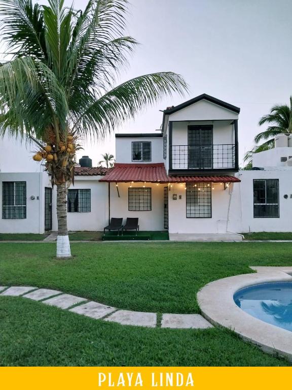 a house with a palm tree and a pool at Casa de 4 habitaciones con alberca in Barrio Nuevo