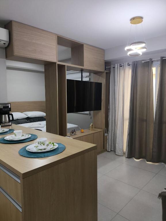 a kitchen and living room with a table with plates on it at Studio Flat - Guarulhos -Airport Aeroporto - Bosque Maia - Cidade Maia in Guarulhos