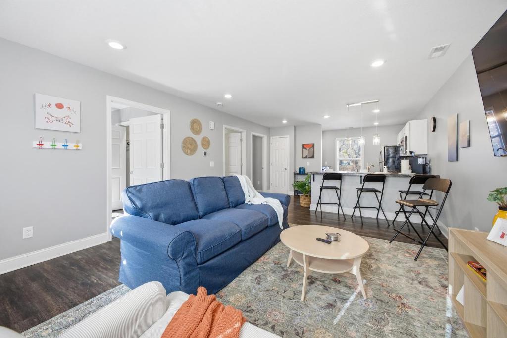 a living room with a blue couch and a table at Sun Valley Loft, Close to Mosaic! in Saint Joseph