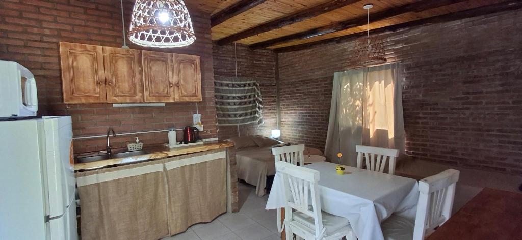 a kitchen with a table and chairs and a refrigerator at Armonia cabaña de campo- Rincón de Afrodita in San Lorenzo