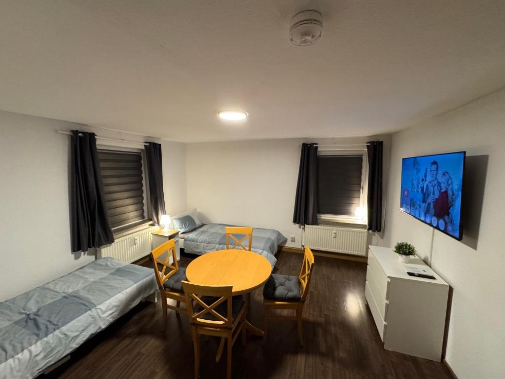 a room with a table and a bed and a bed and a table and chairs at Ferien- und Monteurwohnung in Borna Nr 5 in Borna