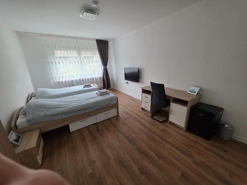 a bedroom with a bed and a desk and a computer at 3-Zimmer Wohnung - 3 OG in Duisburg