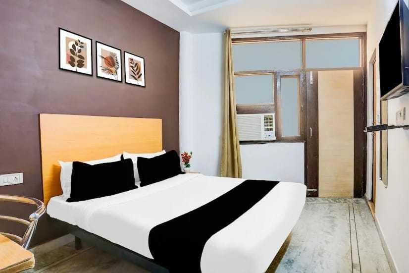 a bedroom with a large bed and a window at Hotel O KL khari Near Ashram Mein Metro in New Delhi
