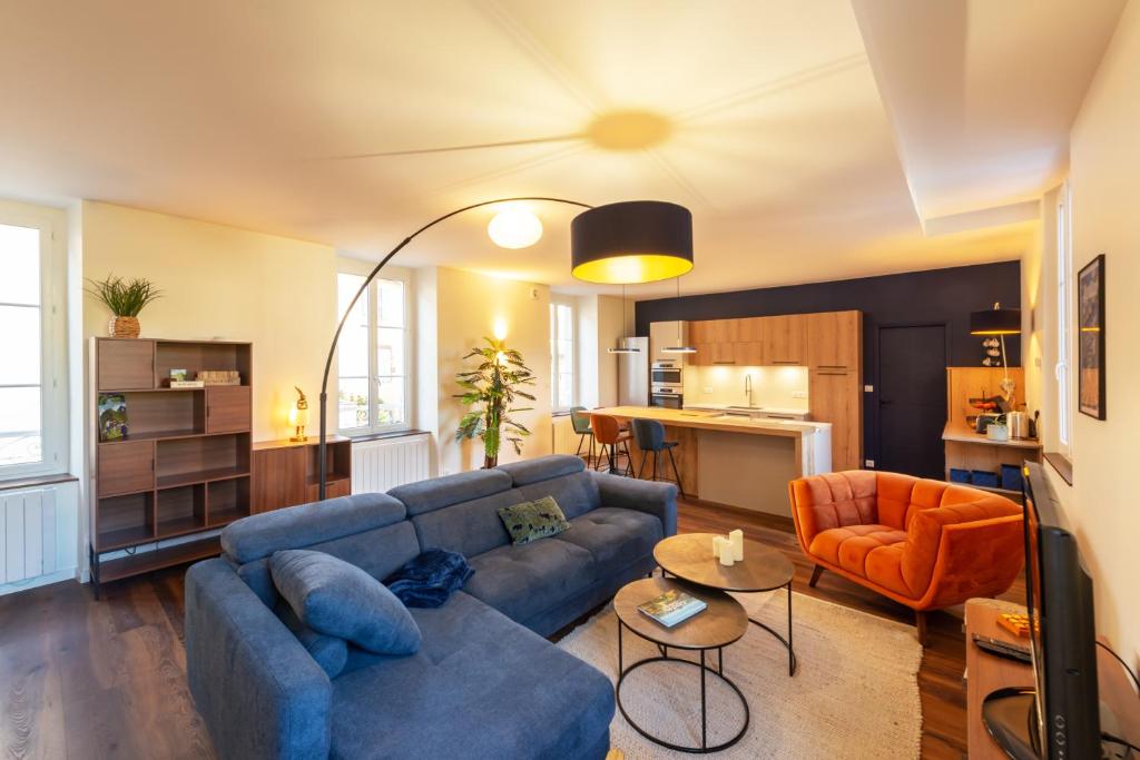 a living room with a blue couch and an orange chair at Le St Géraud, 3 chambres, Prémium avec Fibre, Centre Aurillac in Aurillac