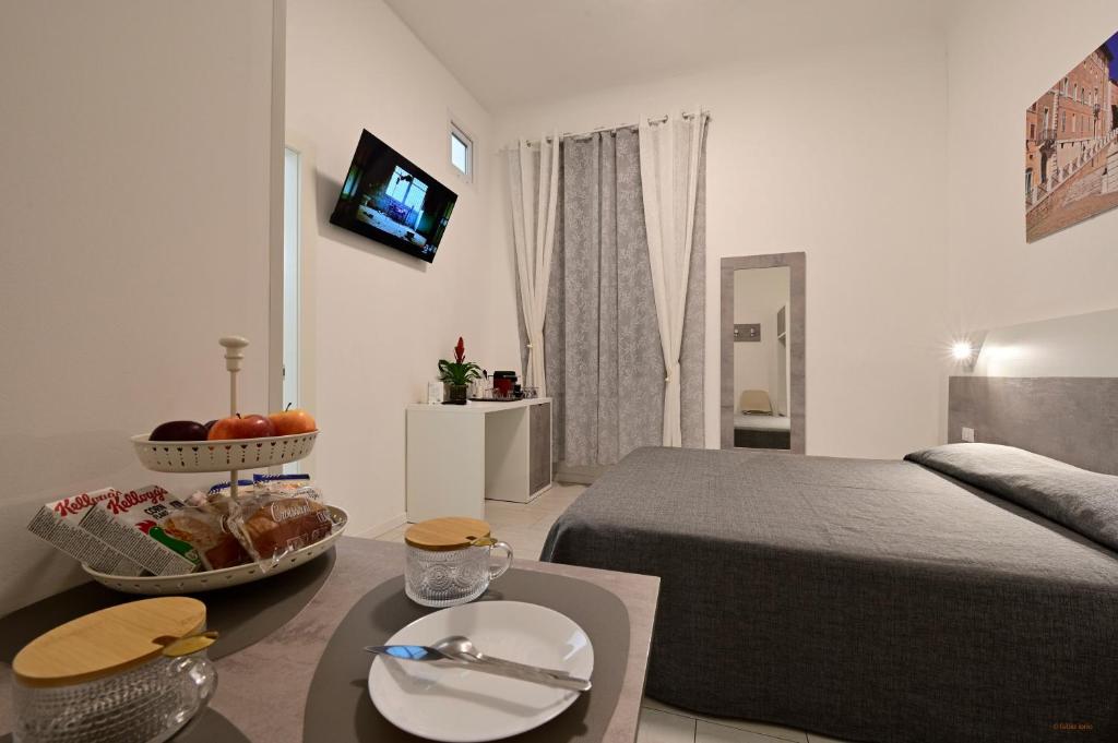 a bedroom with a bed and a table with a bowl of fruit at La Piazza in Ancona
