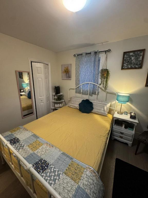 a bedroom with a bed with a yellow bedspread at Peaceful in Moncton