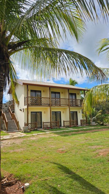 a building with a palm tree in front of it at Pousada do Barão in Lindóia