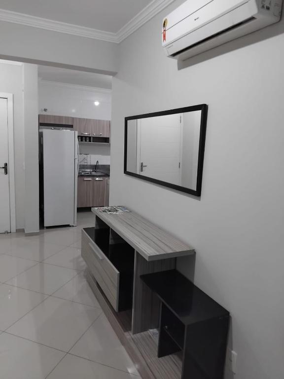 a kitchen with a table and a mirror on a wall at 502 edificio premieri in Piratuba