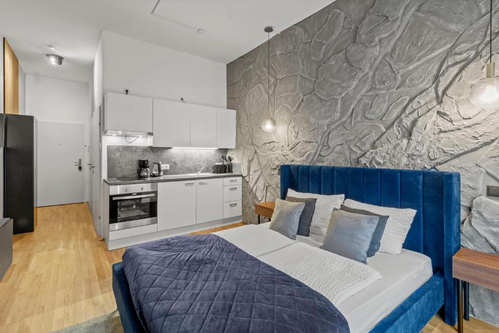 a bedroom with a blue bed and a kitchen at U1 Metro Nearby - 1-BR - fast Wi-Fi in Vienna