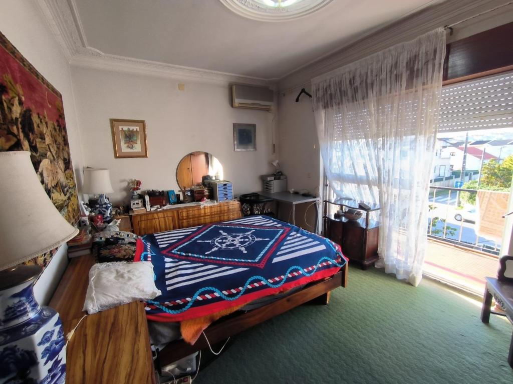 a bedroom with a bed and a large window at GamaBarros1-Charneca in Charneca