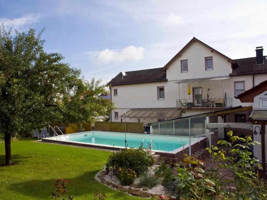 a house with a swimming pool in a yard at Apartment mit Pool und überdachtem Balkon by Interhome in Beerfelden