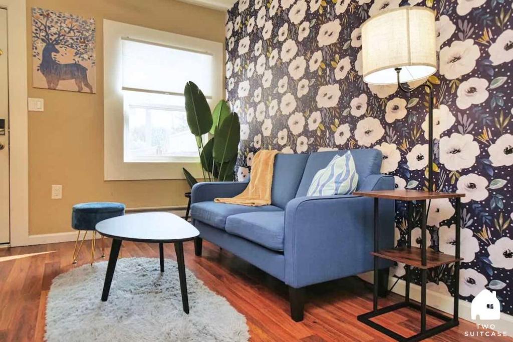 a living room with a blue couch and floral wallpaper at Central Berkeley Garden Oasis in Berkeley