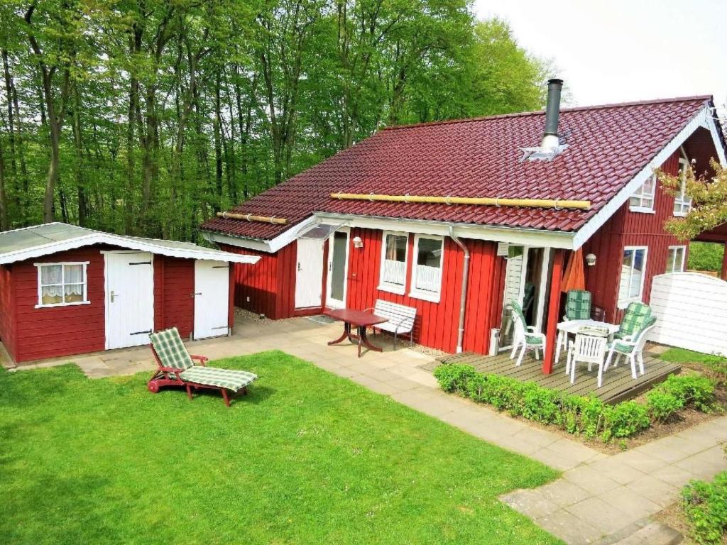 a red and white house with a patio and a yard at Holiday Home Marx by Interhome in Bremke