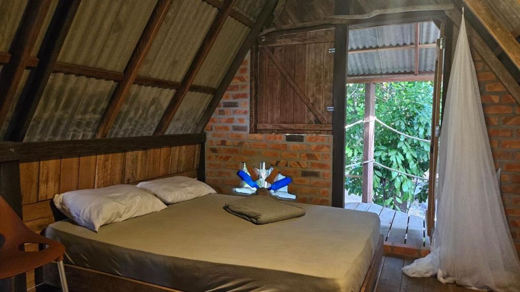 a bedroom with a bed in a room with a window at Florada in Ilha do Maiandeua