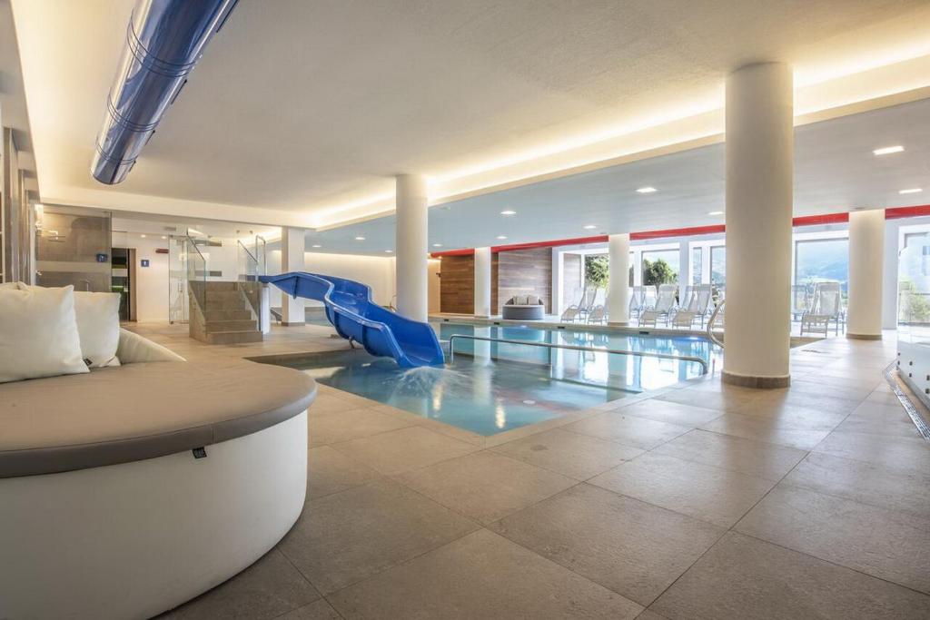 a living room with a pool and a slide at APPARTAMENTI LATEMAR con PISCINA e SAUNA in Cavalese