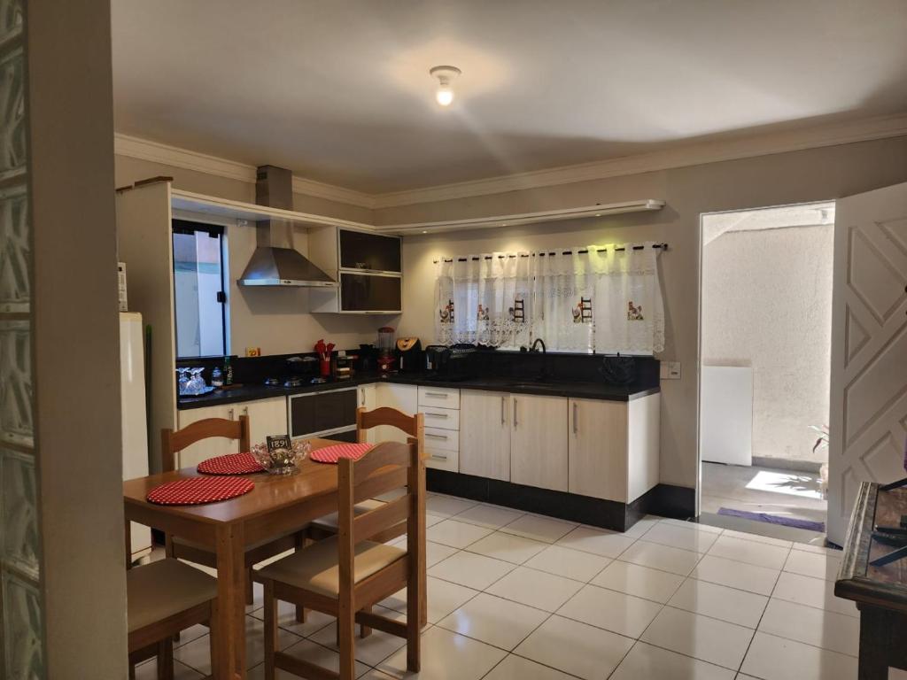a kitchen with a table and a dining room at Loft 150m da praia in Itajaí