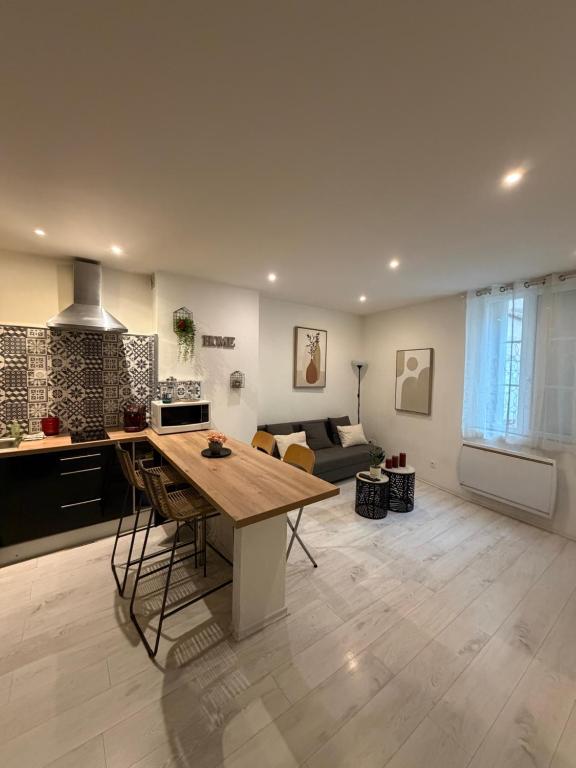 a kitchen and living room with a wooden table at Le Cocon de la Cathédrale au cœur de Metz in Metz