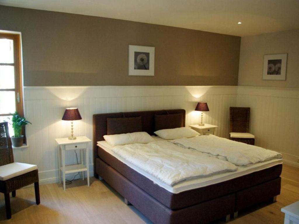 a bedroom with a large bed with two tables and two lamps at Apartment Seerose by Interhome in Bleckede