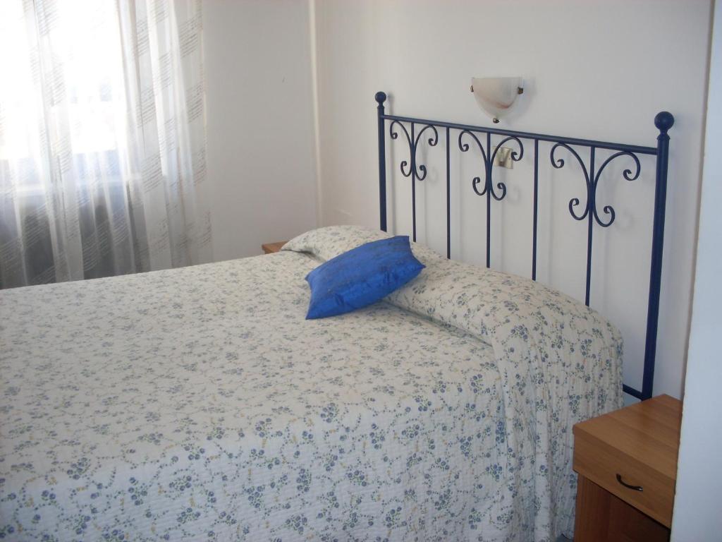 sypialnia z łóżkiem z niebieską poduszką w obiekcie L'Ostu del Povr-Om w mieście Pinasca 