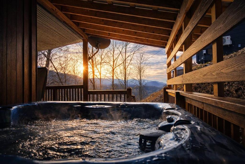 a hot tub in a cabin with a view of the mountains at Distiller's Den in Gatlinburg