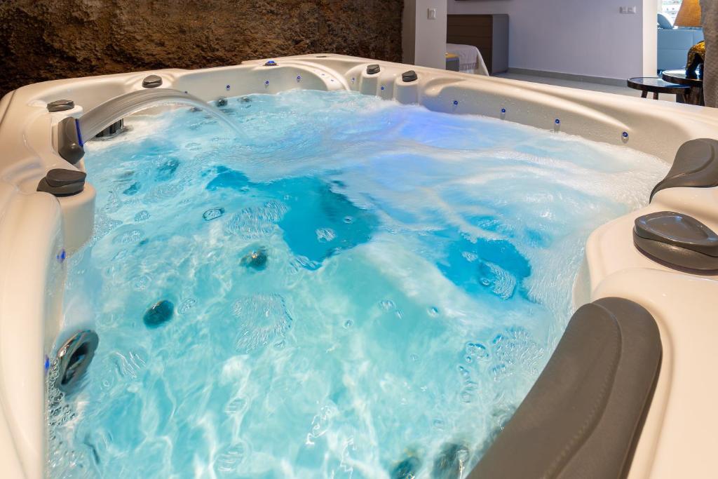 a hot tub with blue water in it at AC Encanto in La Cisnera