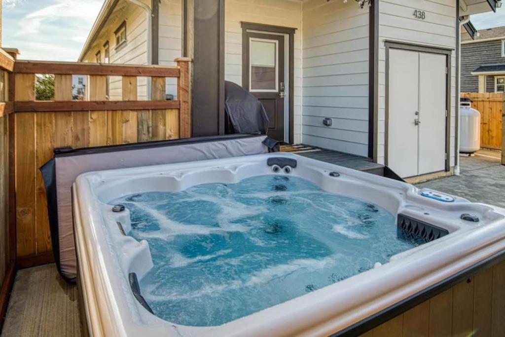 a jacuzzi tub on a patio with a house at Sunflower Beach Cottage in Ocean Shores