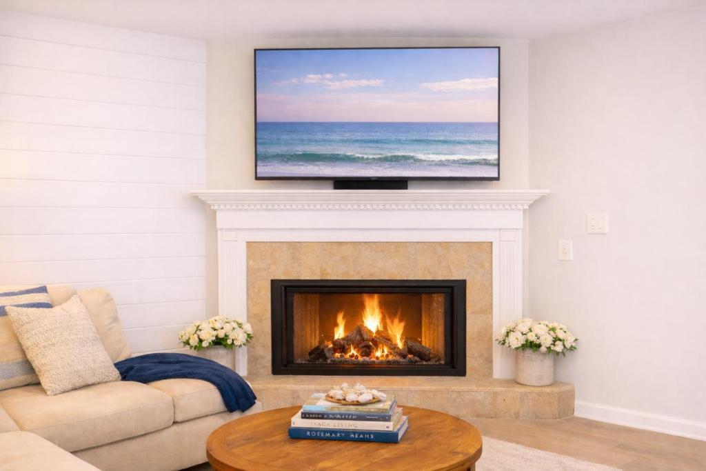 a living room with a fireplace with a television above it at 30A Cottage Near the Beach with Golf Cart in Inlet Beach