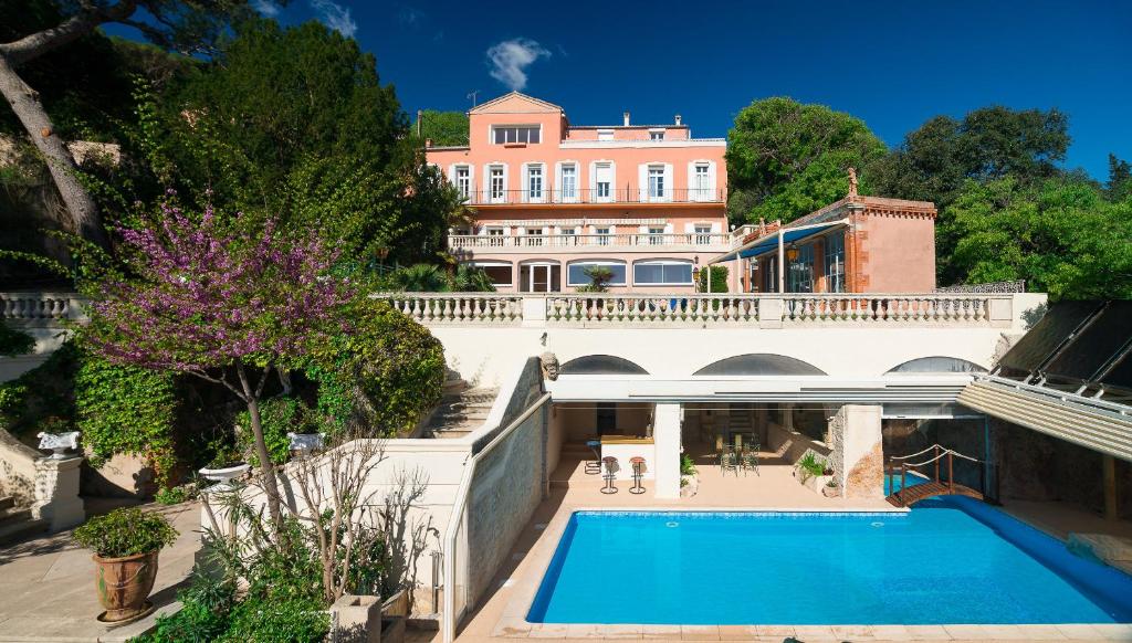 an exterior view of a mansion with a swimming pool at B&B Le Logis Du Mas in Sète