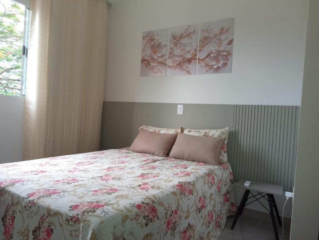 a bedroom with a bed with a floral bedspread at Pousada Ferreira TJ - AP 02 in Cesário Lange