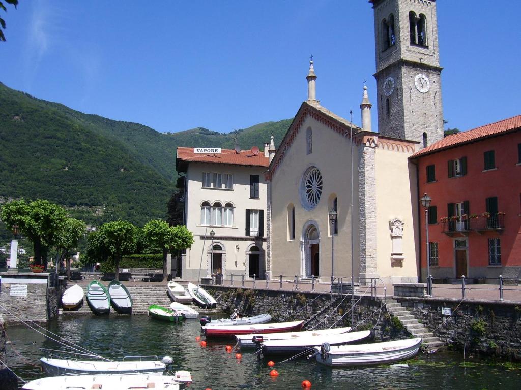 a group of boats in the water in front of a church at Hotel Vapore in Torno
