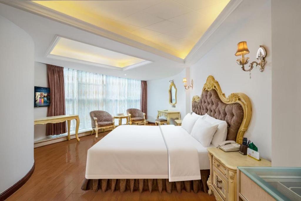 a bedroom with a white bed and a table and chairs at 泽润大酒店 in Chengdu