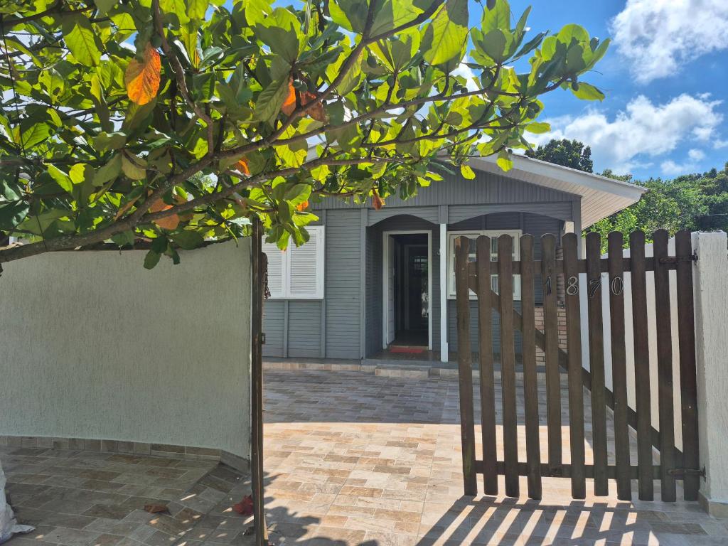 a wooden fence in front of a house at Casa Chalé Ilha Comprida in Ilha Comprida