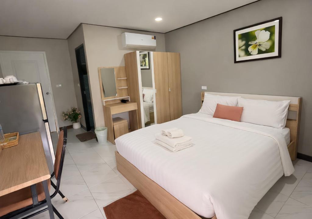 a bedroom with a large white bed in a room at MBB House in Thalang