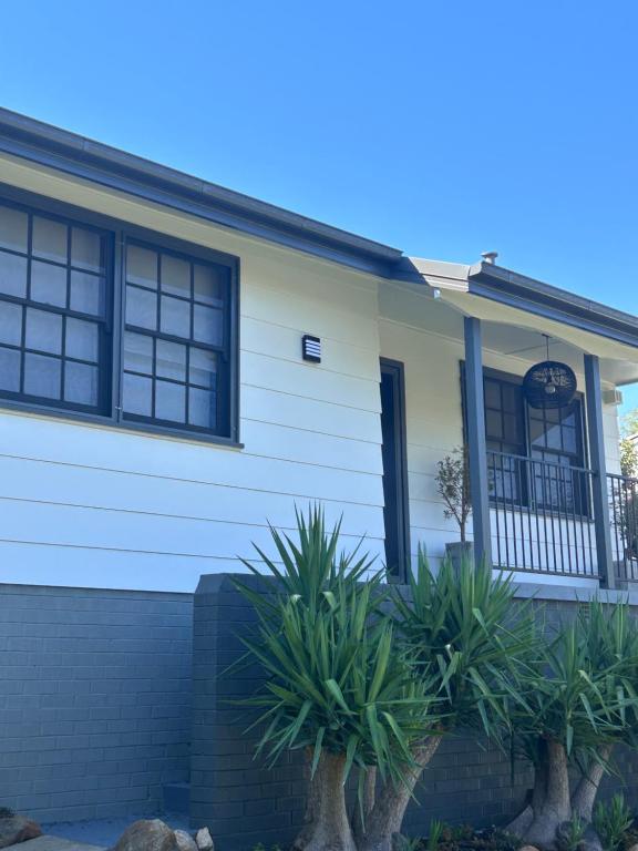a white house with plants in front of it at Watson Street Cottage in Albury