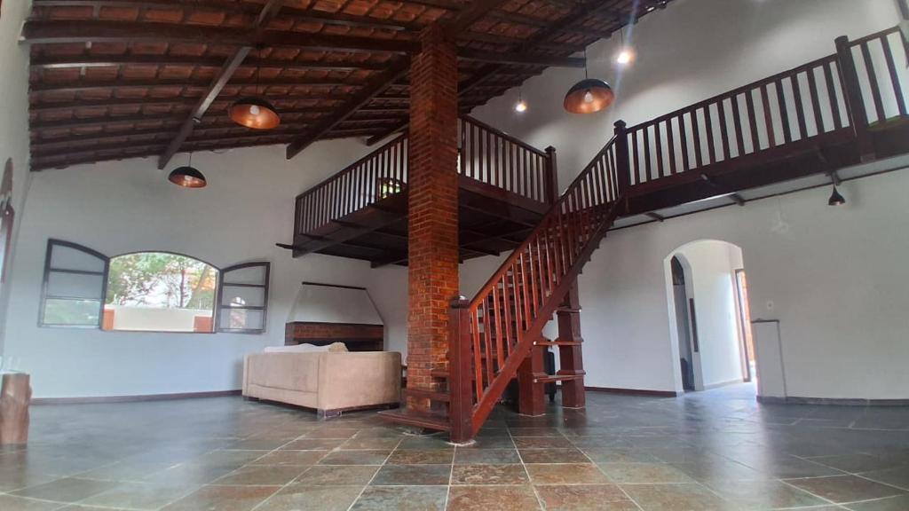a living room with a spiral staircase and a couch at Casa do Sargento in Saquarema