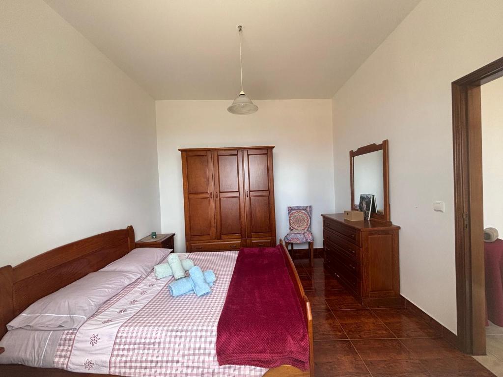a bedroom with a bed and a dresser and a mirror at Casa do Arco in Arco da Calheta