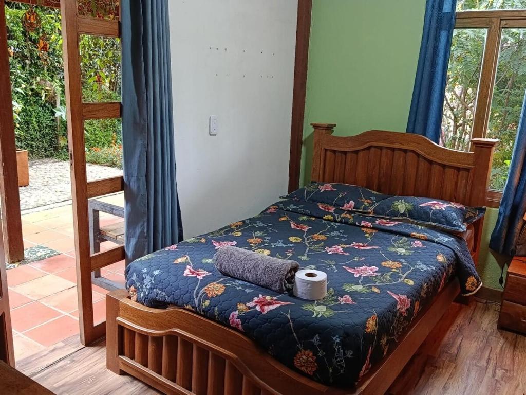 a bed with a blue comforter with a roll on it at Moss in Colombia