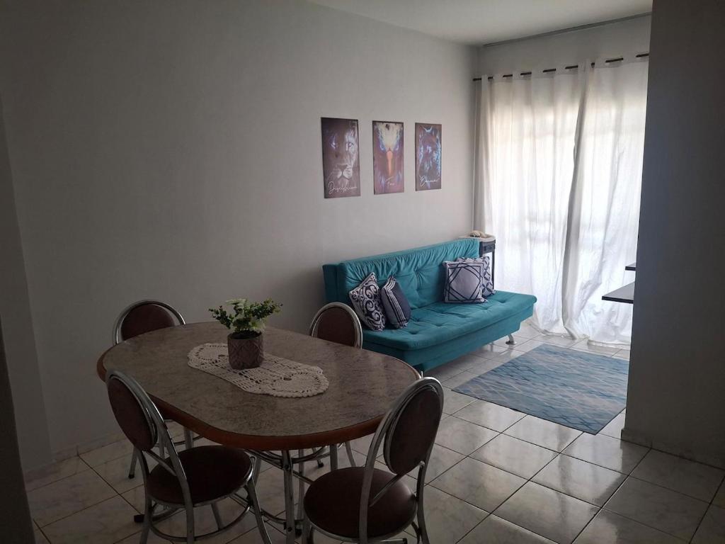 a living room with a table and a blue couch at Aconchego II in Juiz de Fora