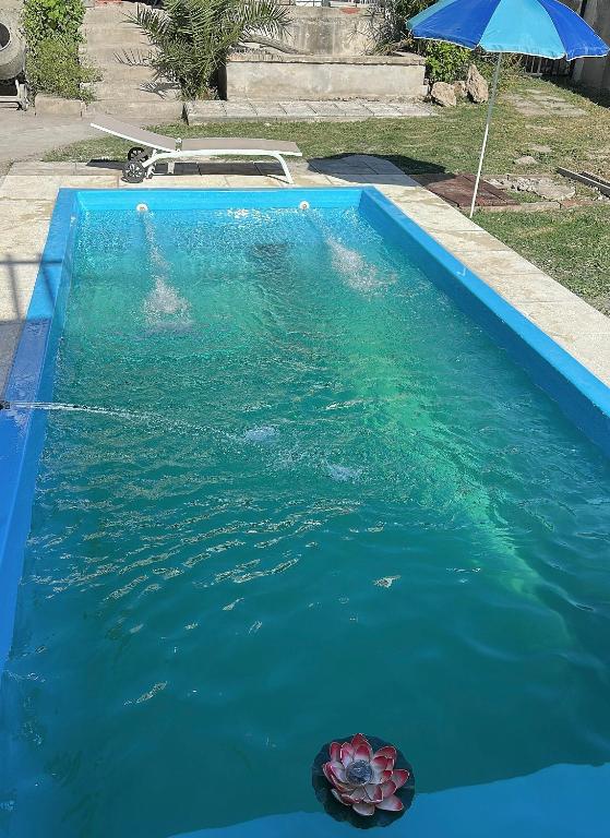a pool with a flower in the water with an umbrella at Casa quinta oro verde in Oro Verde