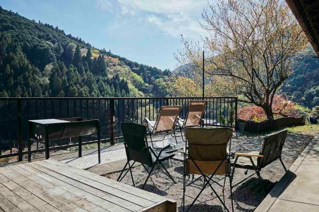 a group of chairs and a table on a deck at Rebe東吉野 in Higashiyoshino