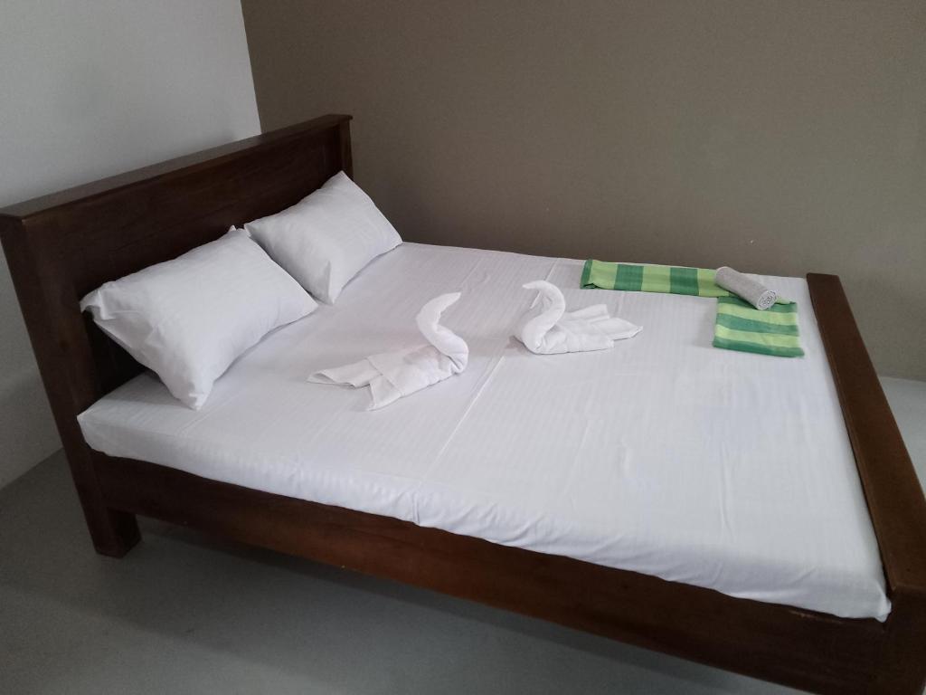 a bed with white sheets and towels on it at Wijaya Garden Hotel in Anuradhapura