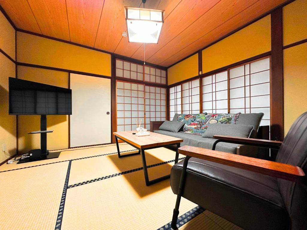 a living room with a couch and a table at MIYABI stay house in Tamana