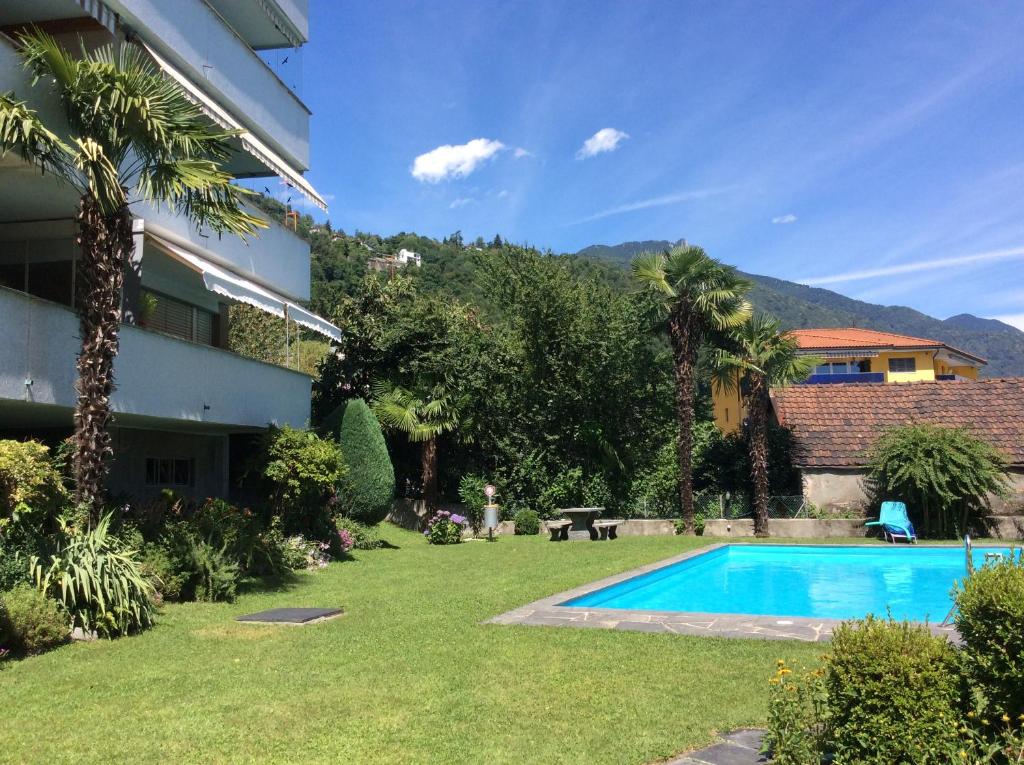 een tuin met een zwembad en een gebouw bij Fiona in Locarno