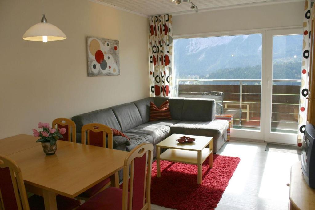 ein Wohnzimmer mit einem Sofa und einem Tisch in der Unterkunft Apartment Bettina by FiS - Fun in Styria in Tauplitz
