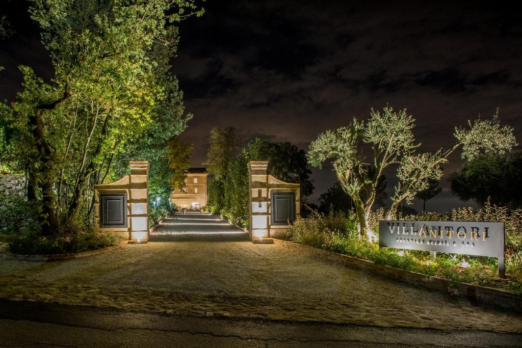 a driveway leading to a mansion at night at Villa Anitori Prestige Relais & Spa in Loro Piceno