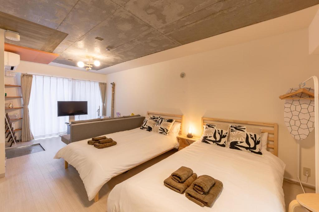 a bedroom with two beds with towels on them at Rafaye N16 in Sapporo