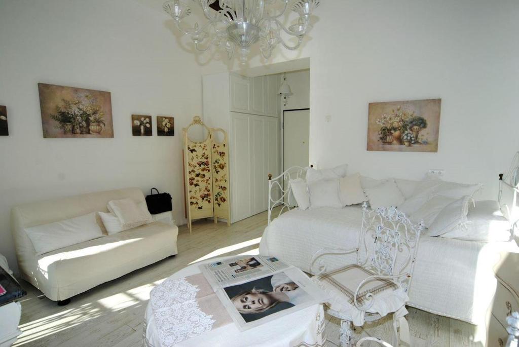 a living room with white furniture and a chandelier at Maison Menton in Menton
