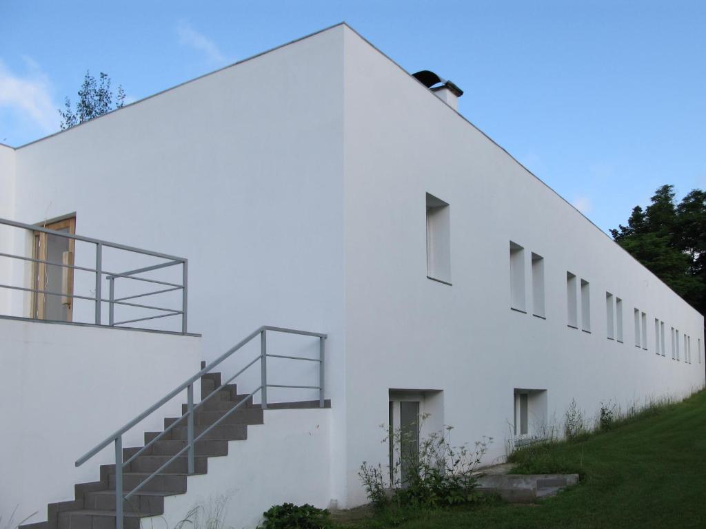 un edificio blanco con escaleras al costado en Pension Lenno we Wleniu en Wleń