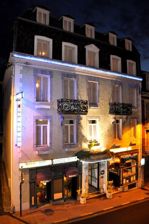 a building with a store in front of it at night at Hotel du Commerce et de Navarre in Lourdes